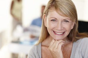 Woman smiling confidently with her new dentures at Torghele and Schmid Dental in Ogden, UT