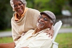 Happy senior couple smiling outdoors after restorative dentistry procedures in Ogden, UT