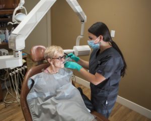 A Torghele Dentistry hygienist works to give x-rays to a patient which is one of the standard menu items on the for general dentistry options. 